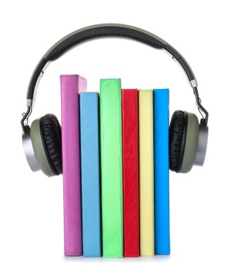 Kitaplar ve beyaz arka planda modern kulaklıklar. Ses kitapçığı kavramı