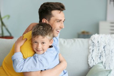 Mutlu baba ve oğulun evde kucaklanması portresi