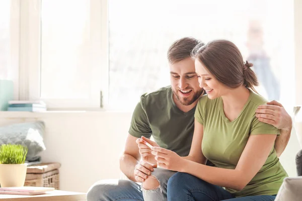 Happy couple with pregnancy test at home — Stock Photo, Image