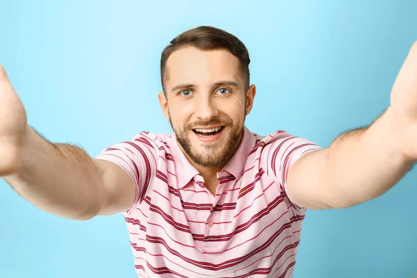 Bonito homem tomando selfie no fundo de cor — Fotografia de Stock