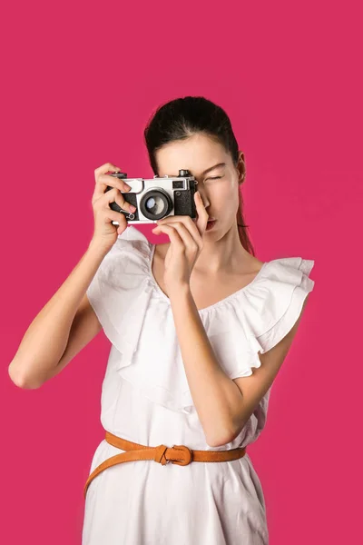 Chica joven con cámara de fotos en el fondo de color —  Fotos de Stock