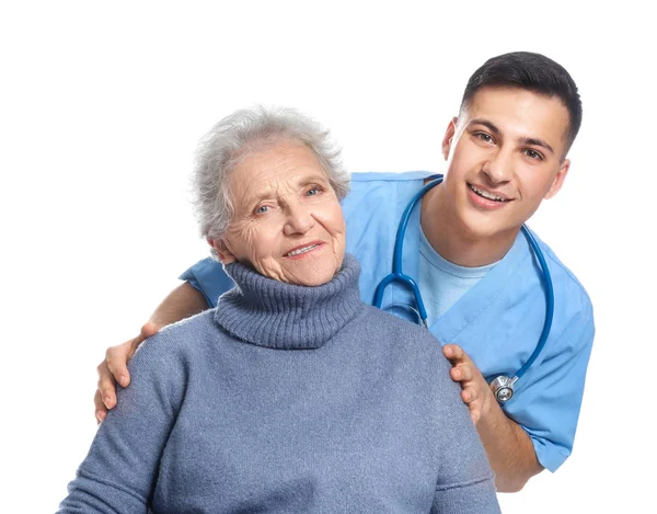 Young caregiver with senior woman on white background — Stock Photo, Image