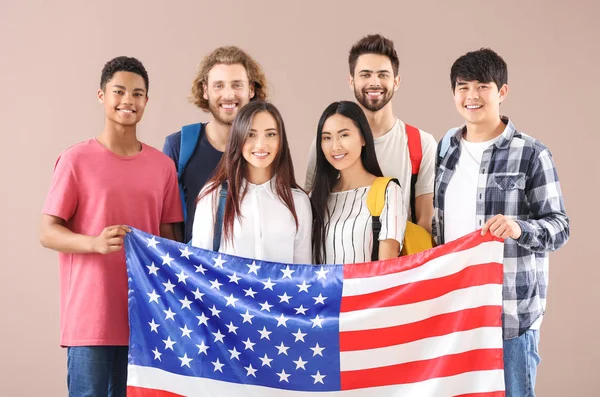 Grupo de estudantes com bandeira dos EUA em fundo de cor — Fotografia de Stock