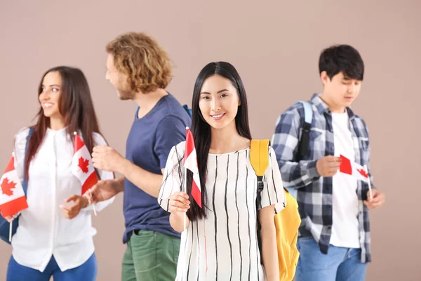 Group of students with Canadian flags on color background — Stock Photo, Image