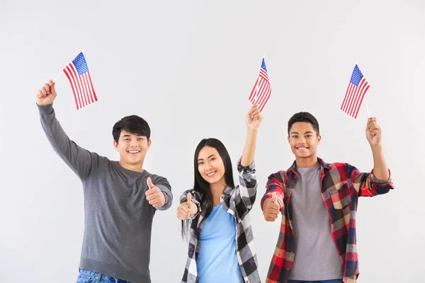 Young people with USA flags on light background