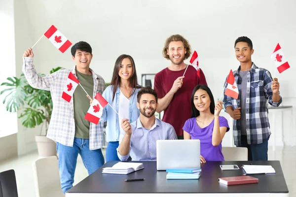 Grupp studenter med kanadensiska flaggor i klassrummet — Stockfoto