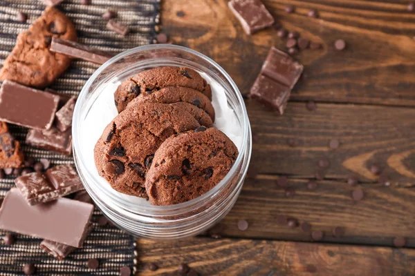 Glass jar with tasty chocolate cookies on wooden table — Stock Photo, Image