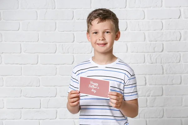 Little boy holding greeting card for Father's Day on white background — Stock Photo, Image