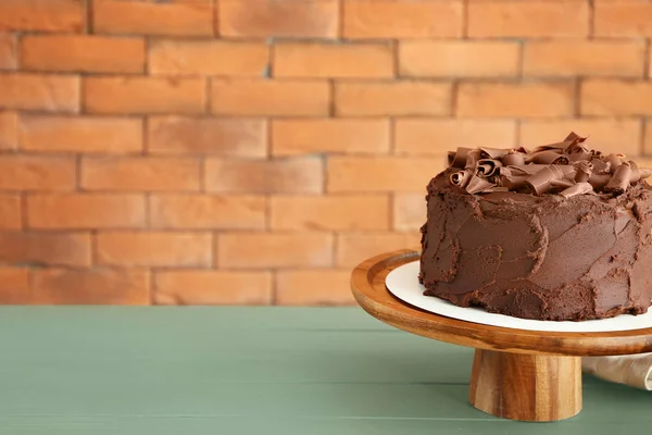 Stand with tasty chocolate cake on table — Stock Photo, Image