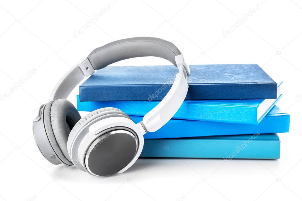 Books and modern headphones on white background. Concept of audiobook