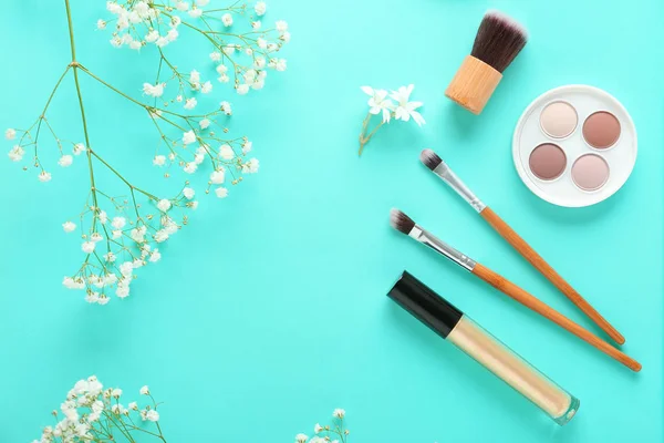 Zestaw ozdobnych kosmetyków i kwiatów na kolorowym tle — Zdjęcie stockowe