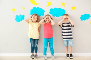 Hafif duvara yakın eğlenen sevimli küçük çocuklar