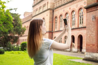 Güzel eski binanın yakınında fotoğraf çeken kadın turist