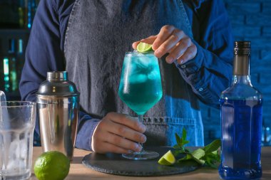 Barkeeper barda masada Blue Lagoon kokteyl hazırlanıyor