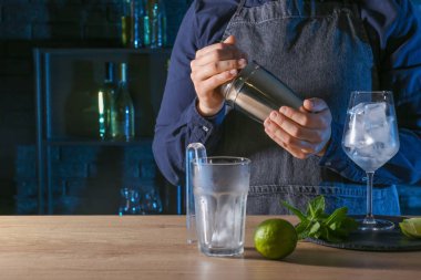 Barmen barda masada soğuk kokteyl hazırlıyor