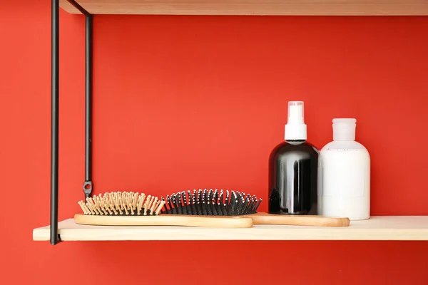 Shampoo and brushes on shelf near color wall