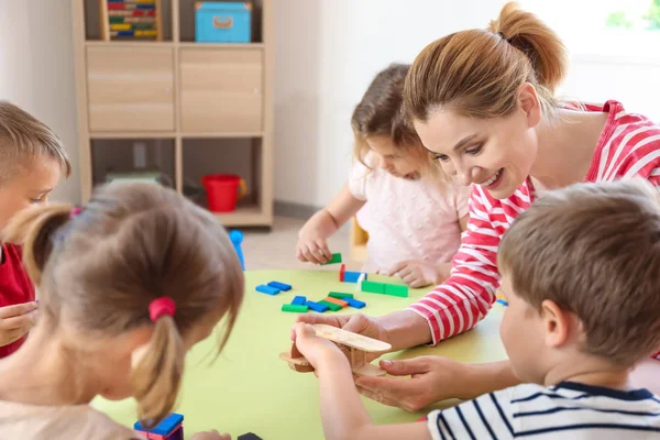 Insegnante di scuola materna con bambini piccoli carini nella scuola materna — Foto Stock