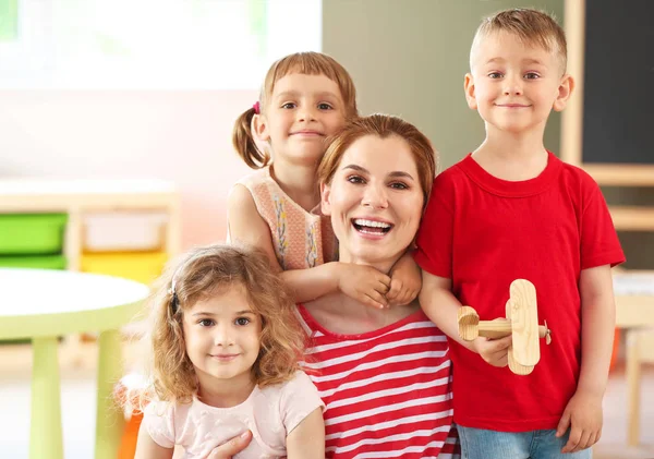 Kwekerij leraar met schattige kleine kinderen in de kleuterschool — Stockfoto