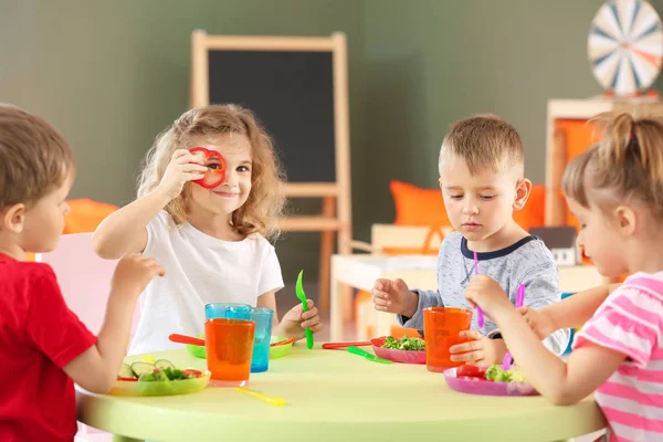 Симпатичні маленькі діти їдять смачний обід в дитячому саду — стокове фото