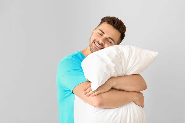 Przystojny mężczyzna przytulanie poduszkę na białym tle — Zdjęcie stockowe