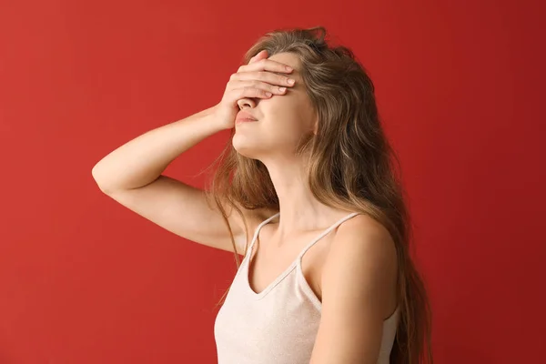 Young woman covering her eyes on color background — Stock Photo, Image