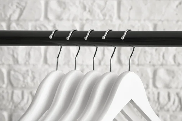 Rack with clothes hangers on white background, closeup — Stock Photo, Image