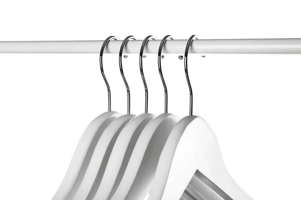Cremalheira com cabides de roupas no fundo branco, close-up — Fotografia de Stock