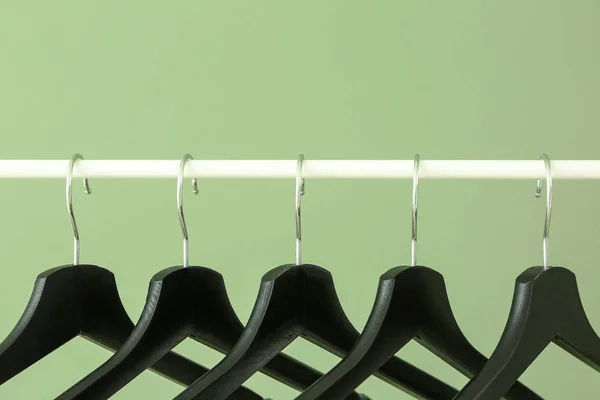 Rack with clothes hangers on color background — Stock Photo, Image