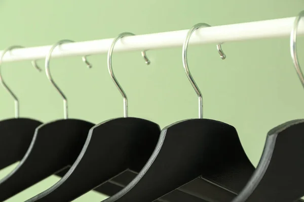 Regál s věšáky na šaty na barevném pozadí, detailní záběr — Stock fotografie