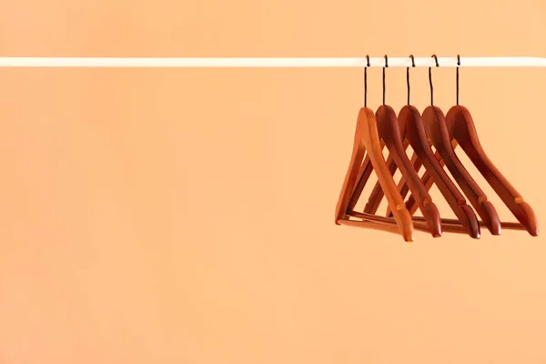 Rack with clothes hangers on color background — Stock Photo, Image