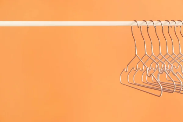 Rack met kleding hangers op kleur achtergrond — Stockfoto