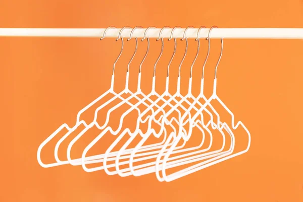 Rack with clothes hangers on color background — Stock Photo, Image