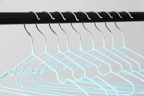Rack with clothes hangers on light background — Stock Photo, Image