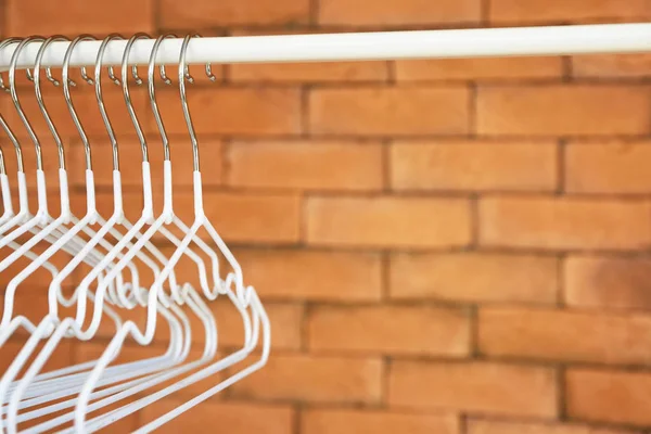 Стойка с вешалками для одежды на кирпичной стене — стоковое фото