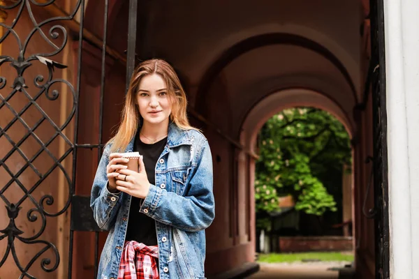 Female tourist with cup of coffee on city street — Stock Photo, Image