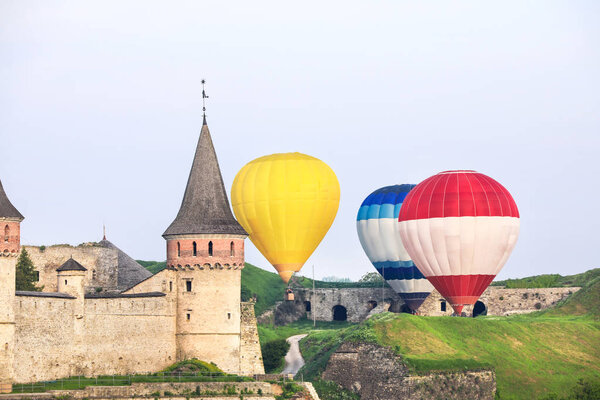 View of old fortress and hot air balloons in countryside