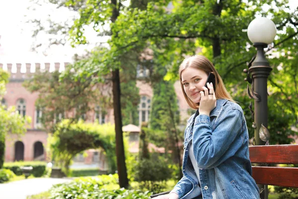 Female tourist talking by mobile phone in beautiful park — Stock Photo, Image