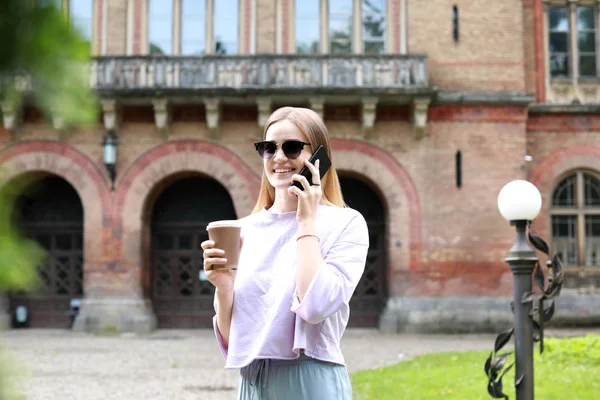 Жінка-туристка розмовляє по мобільному телефону біля красивої старої будівлі — стокове фото
