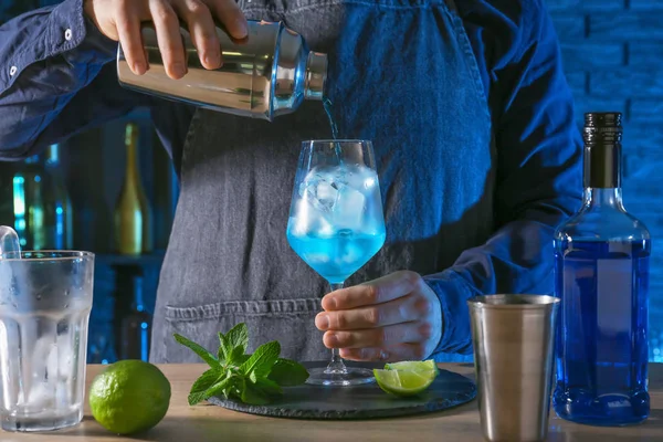 Barkeeper przygotowuje koktajl Blue Lagoon przy stole w barze — Zdjęcie stockowe