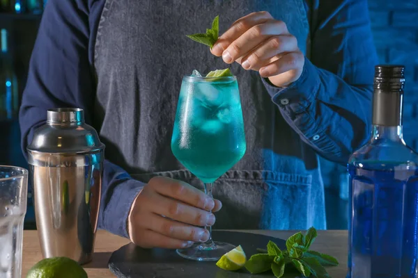 Barkeeper pregătește cocktail-ul Blue Lagoon la masă în bar — Fotografie, imagine de stoc