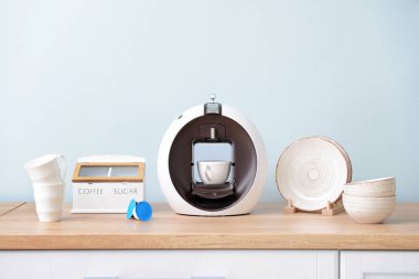 Mutfak masasında modern kahve makinesi ve bulaşık makinesi
