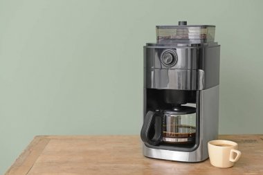 Modern kahve makinesi ve fincan renk arka plan karşı masada