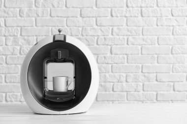 Beyaz duvara yakın masada modern kahve makinesi