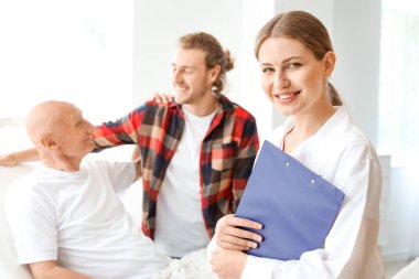 Genç adam modern klinikte yaşlı babasını ziyaret