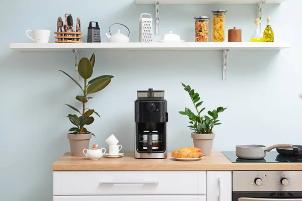 Mutfak masasında modern kahve makinesi, fincanlar ve kruvasan — Stok fotoğraf