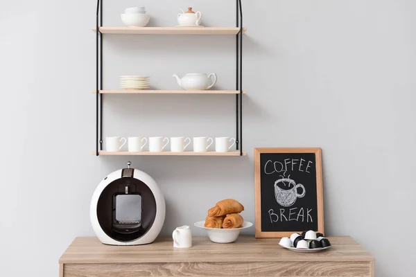 Modern coffee machine and croissants on kitchen table — Stock Photo, Image