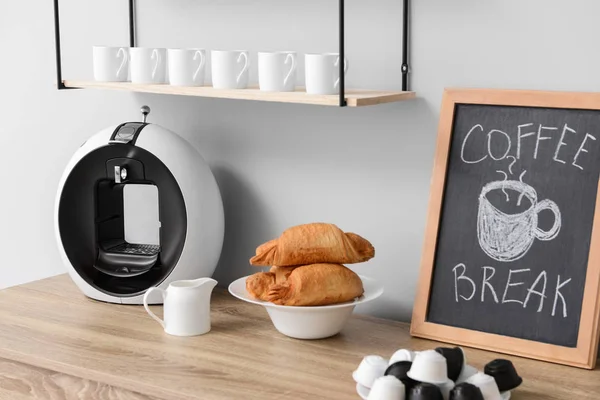 Mutfak masasında modern kahve makinesi ve kruvasan — Stok fotoğraf