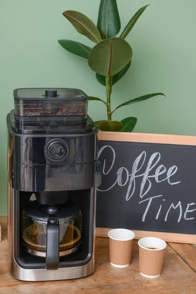 Máquina de café moderna e copos na mesa da cozinha — Fotografia de Stock