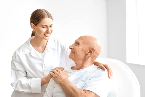 Uomo anziano con medico in clinica moderna — Foto Stock