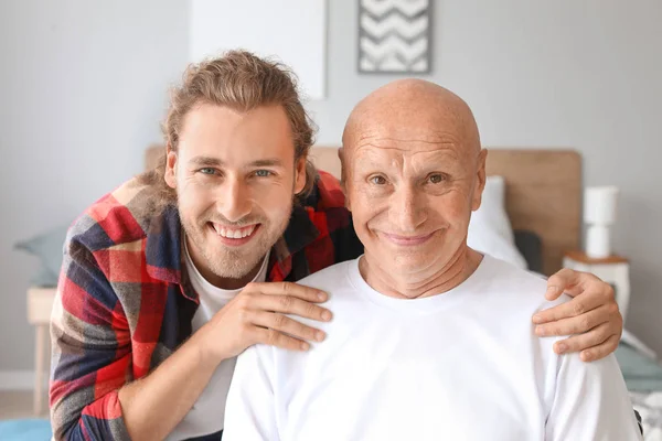 Young man visiting his father in nursing home — Stock Photo, Image